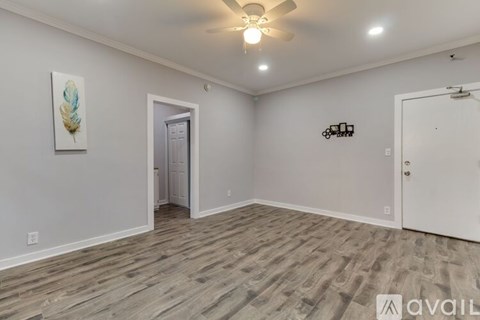 A room with a ceiling fan and a painting on the wall.