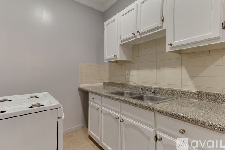 A kitchen with white cabinets and a granite countertop.