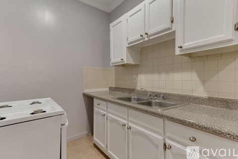 A kitchen with white cabinets and a granite countertop.