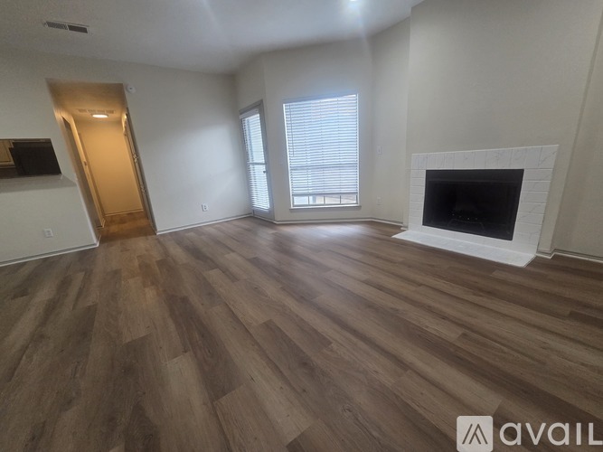 A living room with a fireplace and wooden flooring.