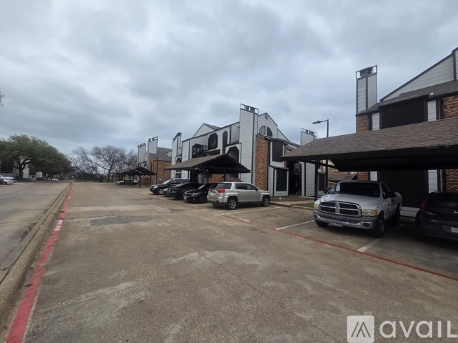 A parking lot with cars and a building in the background.