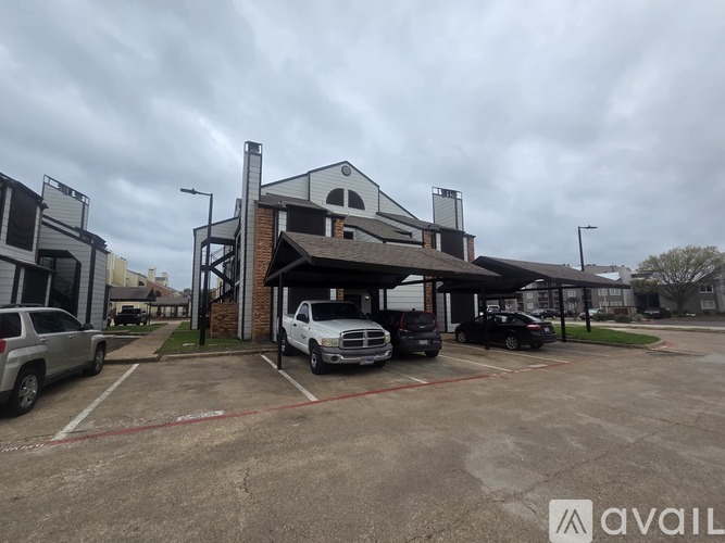 A parking lot with cars and a building in the background.