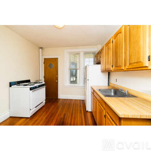 A kitchen with wooden cabinets and a white stove.
