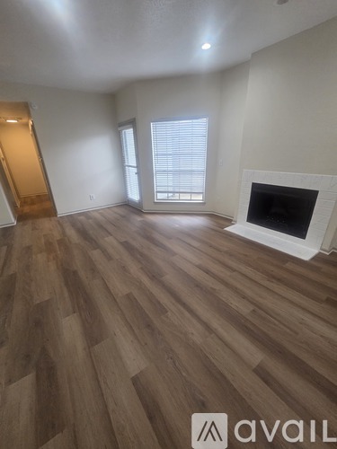 A living room with a fireplace and wood flooring.