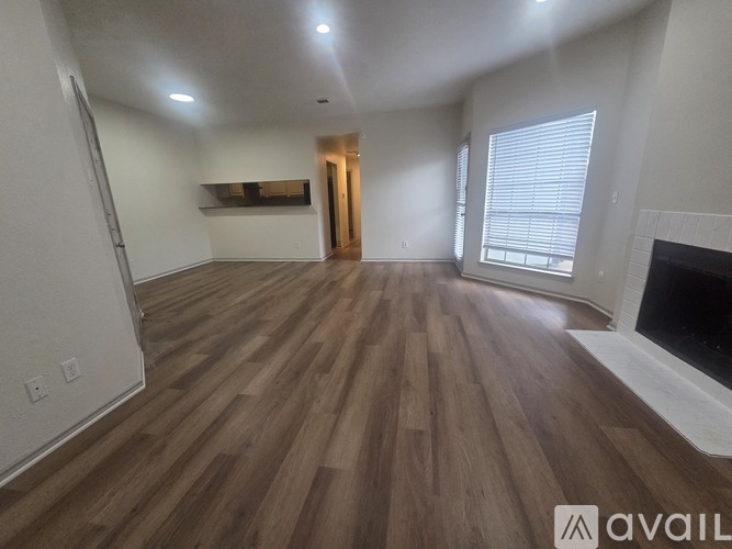A room with wooden flooring and a fireplace.