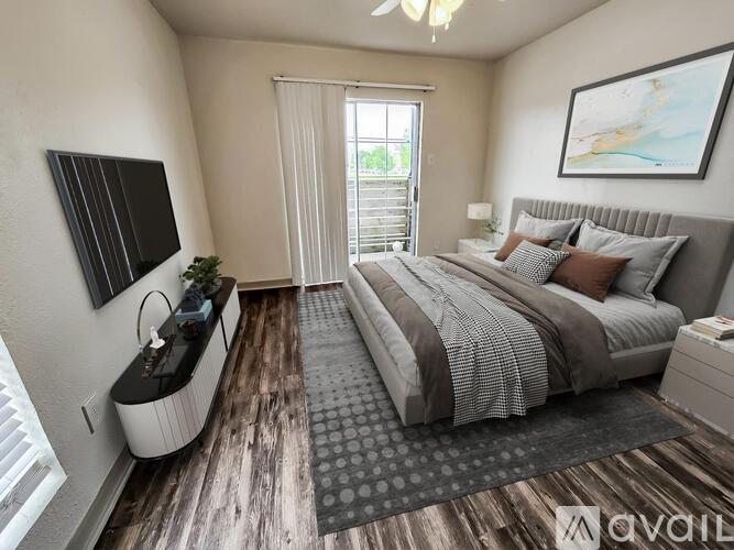 A bedroom with a large bed and a flat screen TV mounted on the wall.