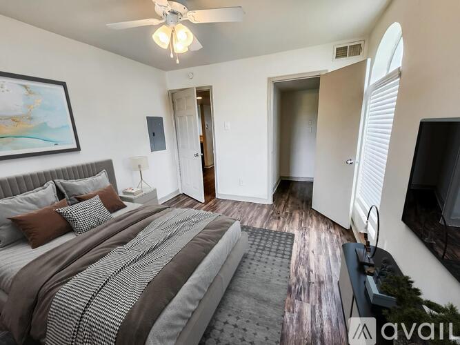 A bedroom with a large bed and a ceiling fan.