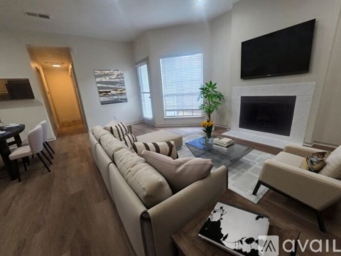 A living room with a long couch and a television mounted on the wall.