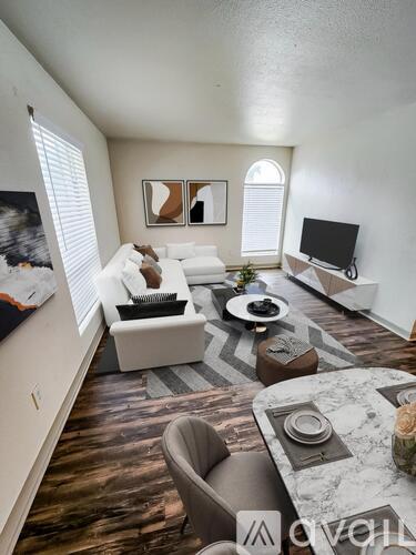 A living room with a white couch, a grey armchair, and a marble coffee table.