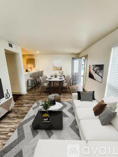 A living room with a white couch and a coffee table in the center.