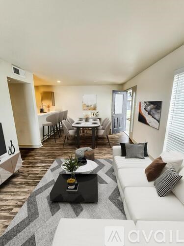 A living room with a white couch and a coffee table in the center.