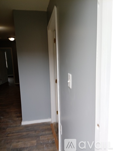 A room with a white door and a wooden floor.