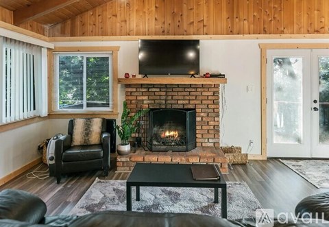 A cozy living room with a fireplace and a television on the wall.