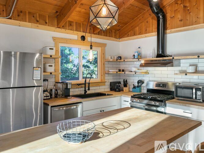 A kitchen with wooden cabinets and a stainless steel refrigerator.