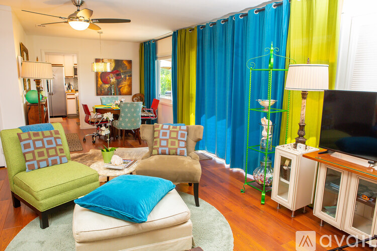 A living room with a green chair and a blue pillow.