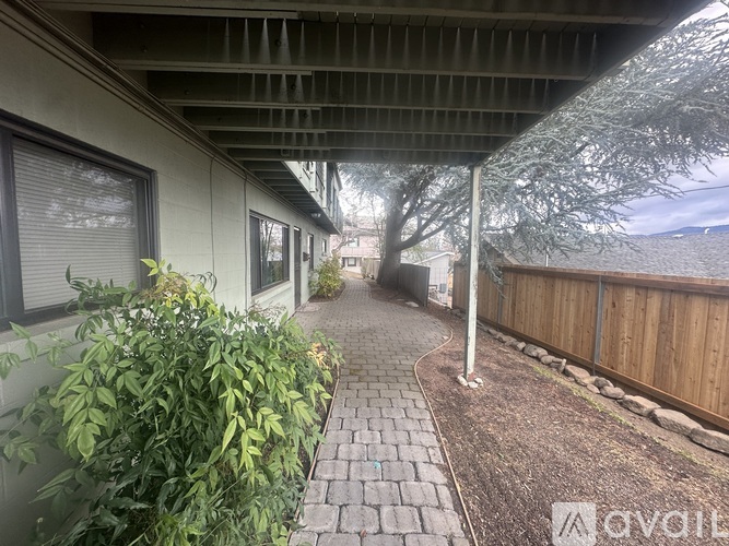 A patio with a brick walkway and a wooden fence.