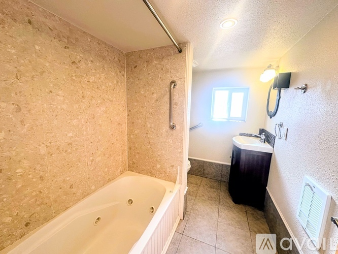 A bathroom with a tub, toilet, and sink.
