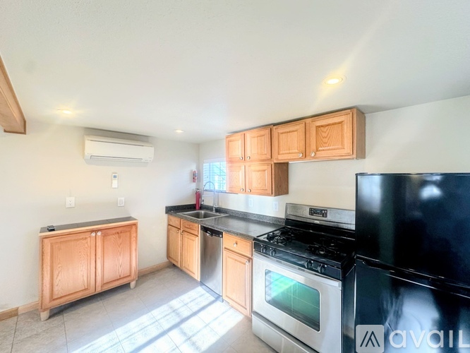 A kitchen with wooden cabinets and black appliances.