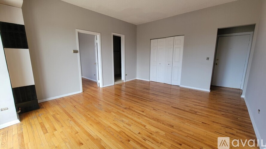 A room with wooden flooring and four doors.