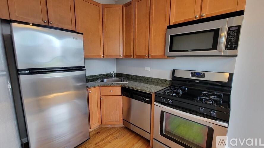 A kitchen with wooden cabinets and a stainless steel refrigerator.