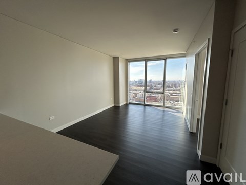A room with a large window overlooking a cityscape is available for rent.