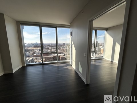 A spacious room with large windows overlooking a cityscape.