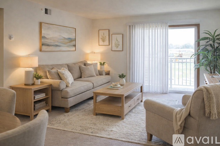 A living room with a couch, chair, and a painting on the wall.