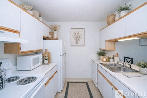 A kitchen with white cabinets and a white stove top oven.