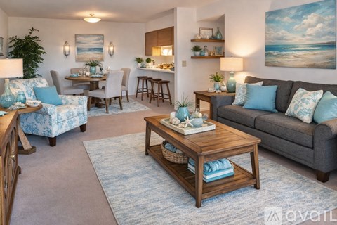 A living room with a grey couch, a wooden coffee table, and a painting on the wall.