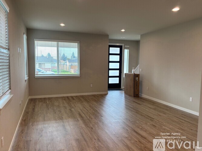 A room with wooden flooring and a large window.