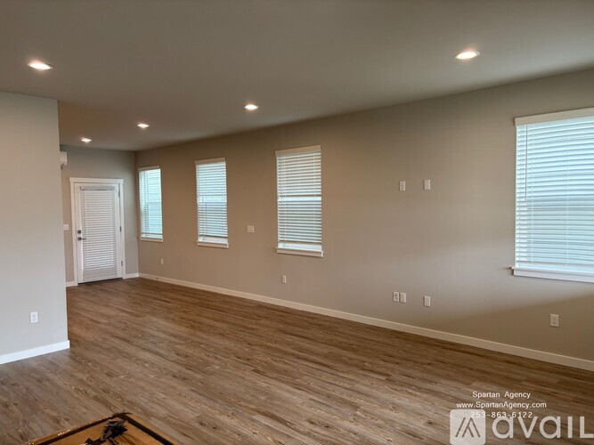 A room with wooden flooring and white walls.