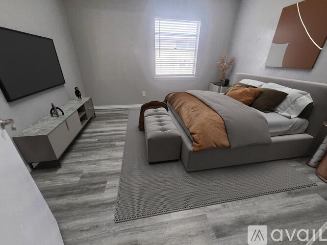 A modern bedroom with a large bed and a TV on the wall.
