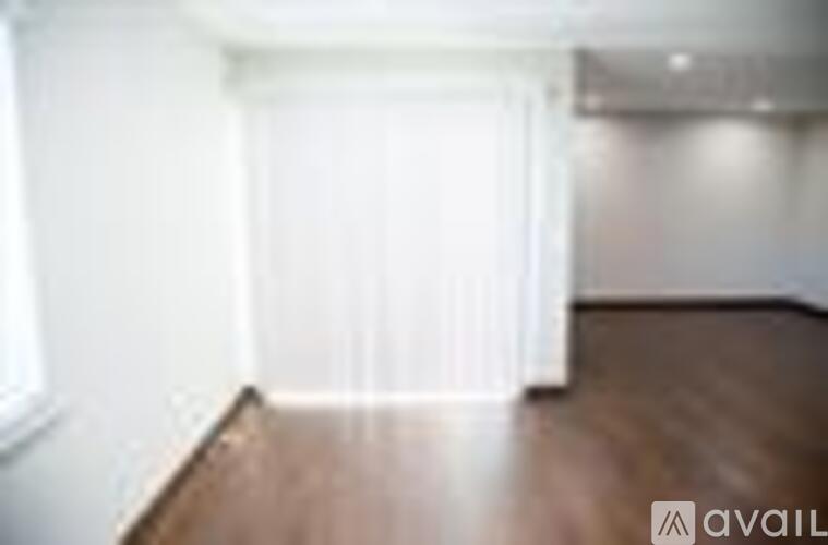 A room with wooden flooring and white walls.