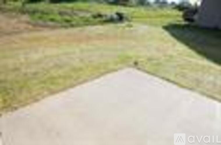 A concrete pathway leads to a grassy area.