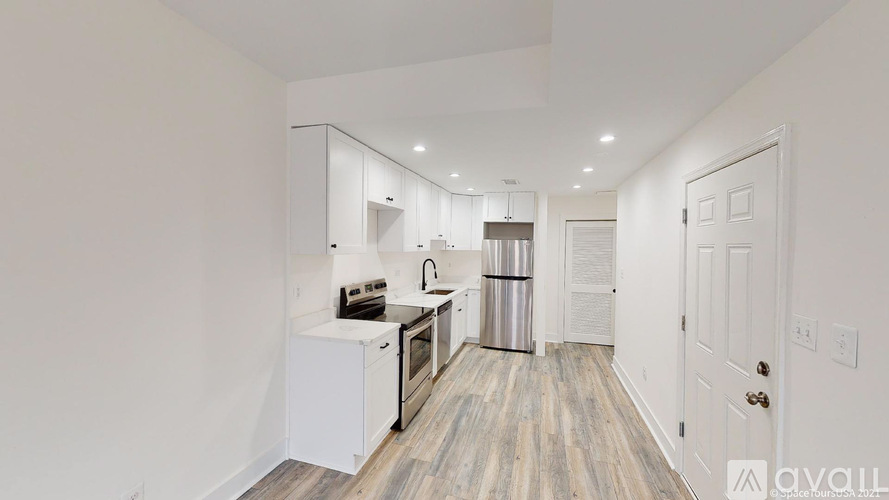 A kitchen with white cabinets and a wooden floor.