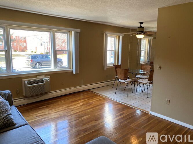 A living room with a couch, chairs, and a ceiling fan.