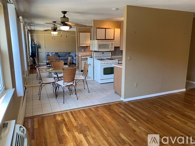 A kitchen with a dining table and chairs is visible from the living room.