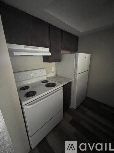 A kitchen with a white stove and a white refrigerator.