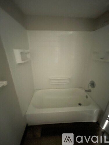 A bathroom with a toilet, sink, and wooden floor.