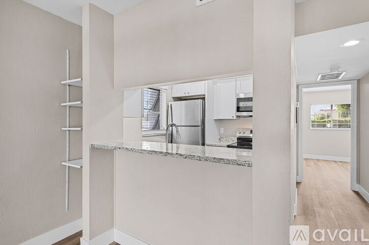 A modern kitchen with a marble countertop and stainless steel appliances.