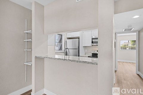 A modern kitchen with a marble countertop and stainless steel appliances.
