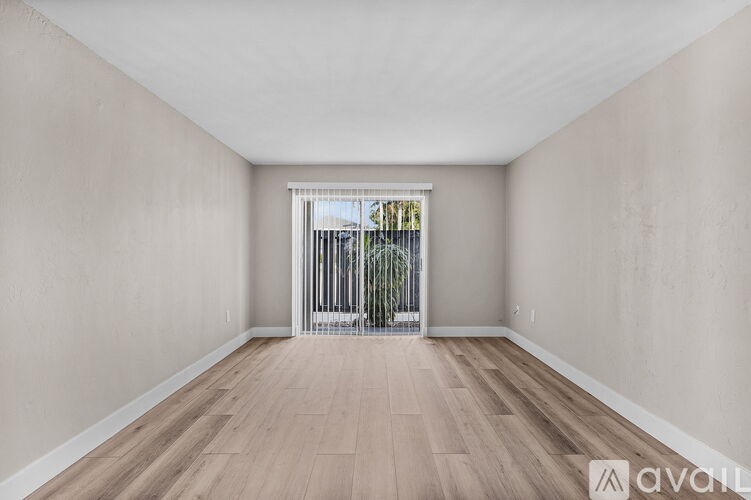 A room with wooden flooring and a window with bars on it.