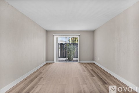 A room with wooden flooring and a window with bars on it.