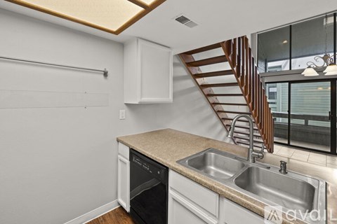 A kitchen with a stainless steel sink and a stainless steel dishwasher.