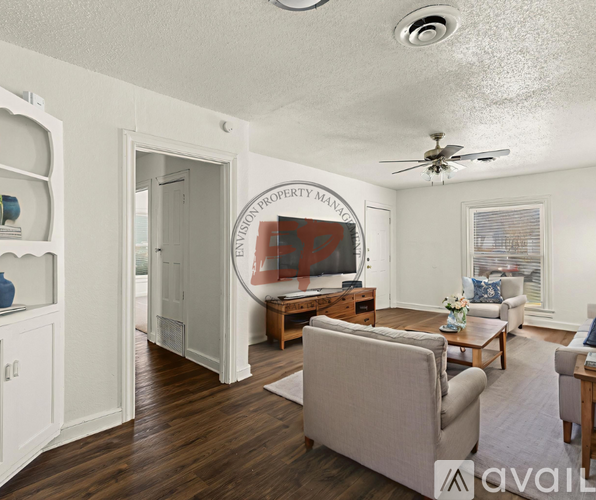 A living room with a couch, chairs, and a painting on the wall.