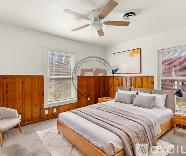 A bedroom with a large bed and a ceiling fan.