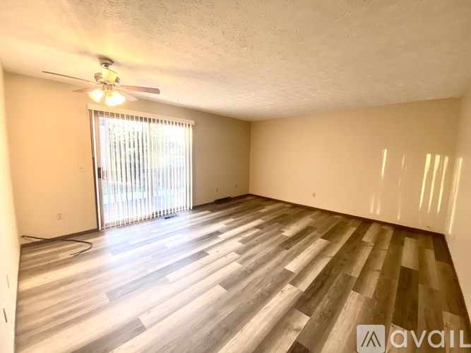 A room with wooden flooring and a ceiling fan.