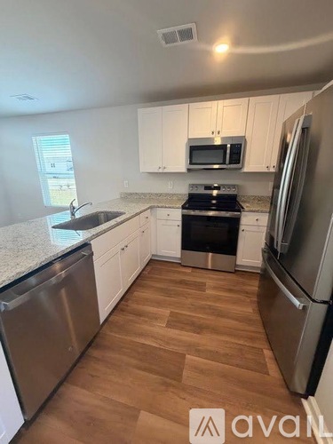 A kitchen with wooden floors and stainless steel appliances.