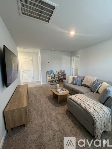 A living room with a grey couch, a wooden bench, and a coffee table.