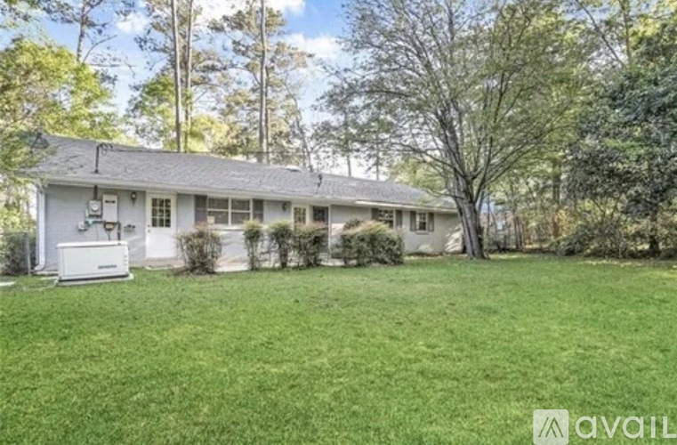 A house with a lawn and trees in the background.